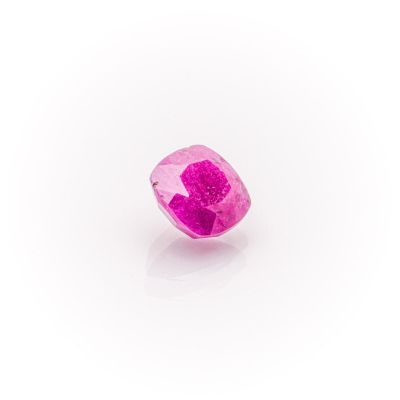 a close up of a pink diamond on a white surface