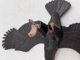 a black bird that is sitting on top of a piece of wood