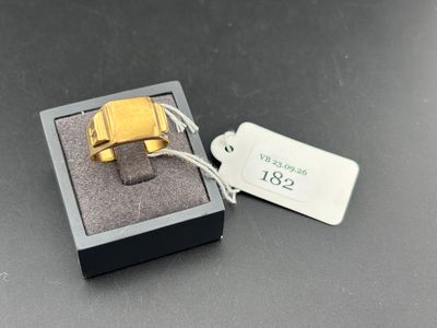 une bague en or dans une boîte noire sur laquelle est apposée une étiquette de prix