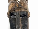 an old wooden mask hanging on a wall on a white background