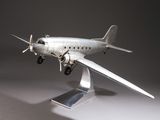 une maquette en argent représentant un petit avion, posée sur un socle
