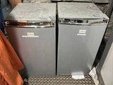two refrigerators sitting next to each other in a room