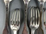 six forks and spoons are lined up on a table