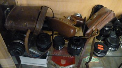 de nombreux modèles d'appareils photo posés sur une étagère en verre