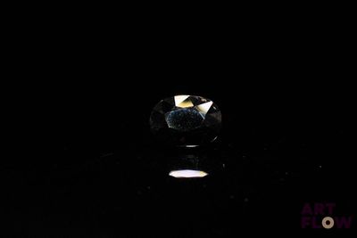 a close up of a diamond in the dark on a table