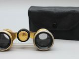 une vieille paire de jumelles posée sur un étui noir