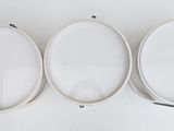 three white oval mirrors on a white surface with a white background