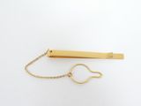a gold tie bar with a chain attached to it
