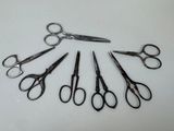 several pairs of scissors are arranged in a circle on a white surface
