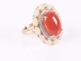 a close up of a ring with a red stone surrounded by white stones