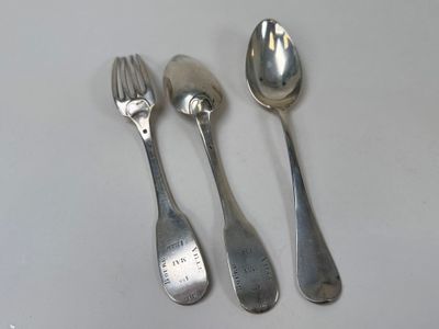three spoons and two spoons sitting on a table