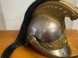 a silver helmet with a long black hair on a wooden table