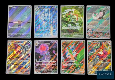 Les cartes Pokémon sont alignées sur une surface noire.