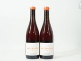 deux bouteilles de vin posées l'une à côté de l'autre sur une surface blanche