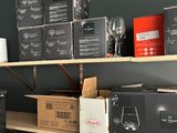 many boxes of wine glasses on the shelves in the room