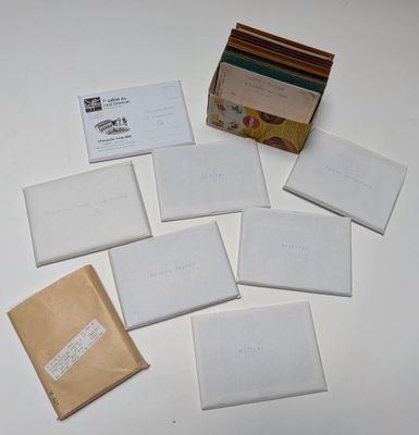 Plusieurs enveloppes sont posées sur une table blanche, à côté d'un sac marron.