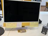 a computer monitor sitting on a desk in an office