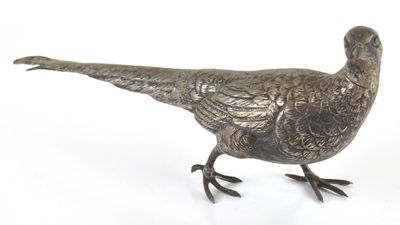 un oiseau en métal posé sur une surface blanche