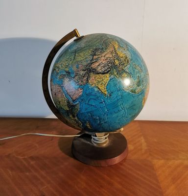 a small blue and green globe on a wooden table