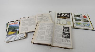 an open book sitting on top of a white table next to a pile of books
