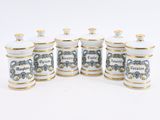 six white and gold canisters with blue and white designs on them