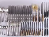 beaucoup d'argenterie sur une table avec des cuillères et des couteaux