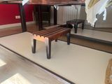 a wooden bench sitting in front of a mirror in a room