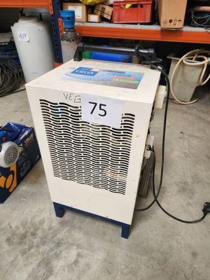 un petit climatiseur posé par terre dans un garage