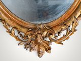 a mirror with a gold frame on the wall