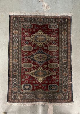a red and black rug hanging on a wall