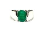 a close up of a ring with a green stone on it
