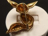 a close up of a brooch with a flower on it