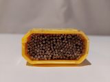 a yellow container filled with black beans on a white table