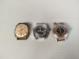 three different types of watches sitting on a white surface