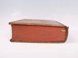 an old book that is sitting on a white surface