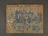 an old sign hanging on the wall of a building