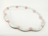 plateau ovale orné de perles, avec des fleurs roses sur fond blanc
