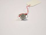 a silver ring with a red string and a tag on it
