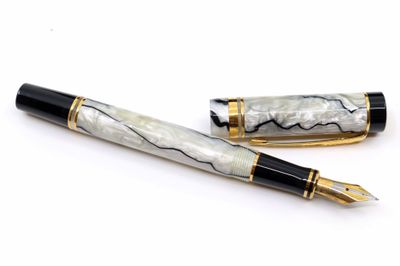deux stylos à plume posés l'un à côté de l'autre sur une surface blanche