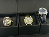 three watches are in a black box on a black surface