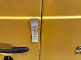 a measuring tape on the door of a yellow car