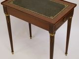 a small wooden table with a green top and gold trimming