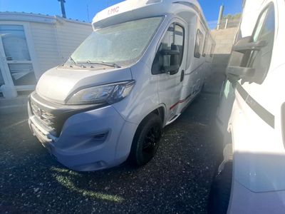 une photo d'un camping-car blanc garé sur un parking