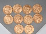 six gold sovereigns are arranged in a triangle on a gray surface