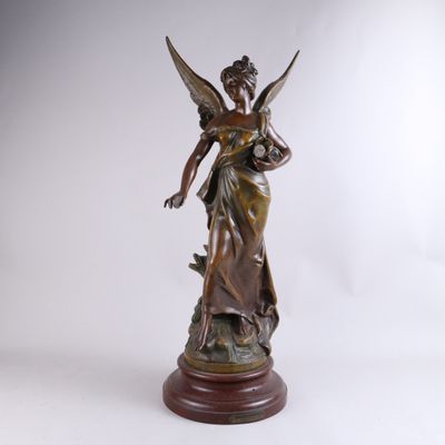a bronze statue of a woman holding a bird on top of a wooden base