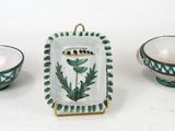 three pieces of pottery sitting on a white surface