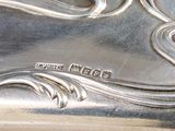 a close up of a silver plate with a bird on it