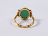 a close up of a gold ring with a green stone