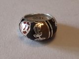une bague en argent ornée d'un motif noir et rouge