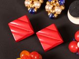 a close up of a pair of red and blue earrings